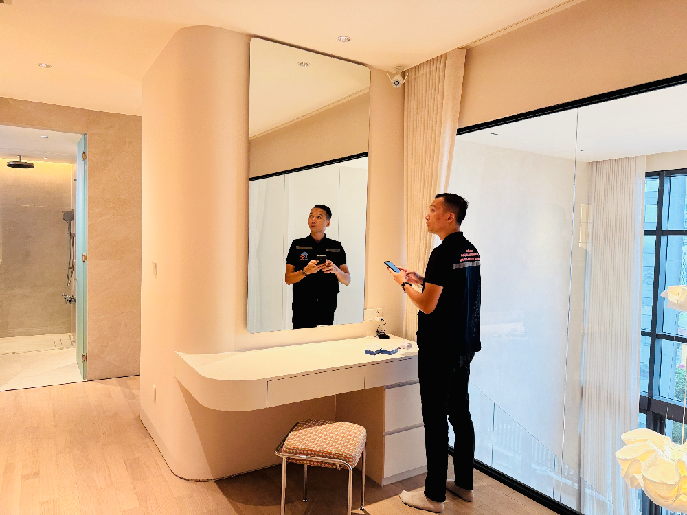 Người đàn ông cầm điện thoại trước gương trong phòng tắm