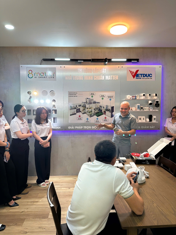 Người đàn ông trình bày trước nhóm người ngồi quanh bàn ăn