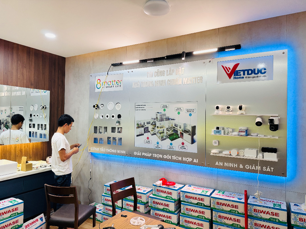 Người đàn ông kiểm tra điện thoại trước màn hình lớn và các hộp